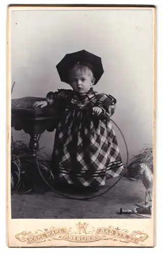 Fotografie Karl Wahl, Berlin-N, Bad-Strasse 32, Portrait kleines Mädchen im karierten Kleid mit Reifen