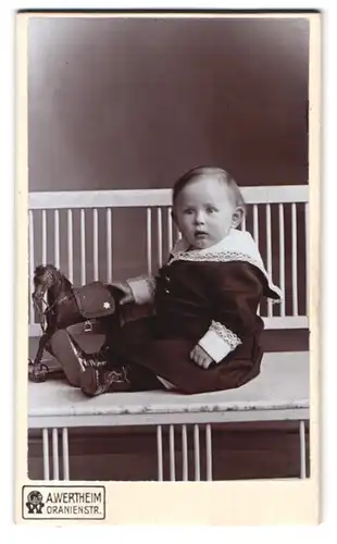 Fotografie A. Wertheim, Berlin, Oranienstrasse, Portrait süsses Kleinkind im Kleid mit Spielzeugpferd