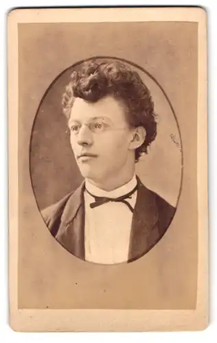 Fotografie H. Mehlert, Meldorf, Portrait junger Mann mit Zwicker und lockigem Haar