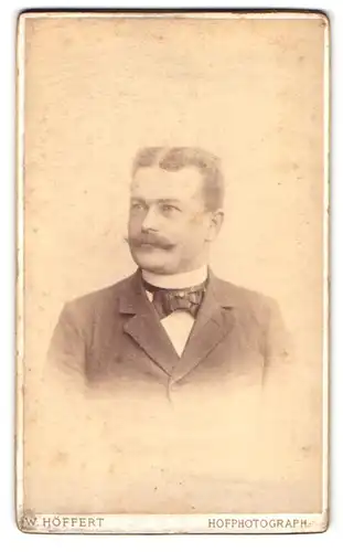 Fotografie W. Höffert, Berlin, Leipzigerplatz 12, Portrait charmanter Herr mit Schnurrbart und Fliege im Jackett