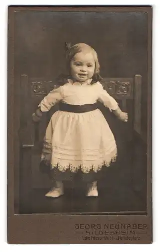 Fotografie Georg Neunaber, Hildesheim, Friesenstr. 14, Portrait lachendes kleines Mädchen im weiss-schwarzen Kleidchen