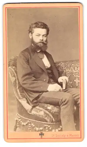 Fotografie Dr. Szekely und Massak, Wien, Elisabethstrasse 1, Mann mit lockigem Haar, Vollbart und Buch in der Hand