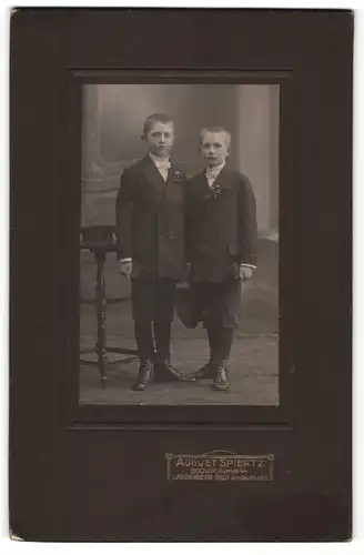 Fotografie August Spiertz, Bochum & Langenberg, Portrait zwei kleine Jungen mit Mütze u. Buch in Anzügen