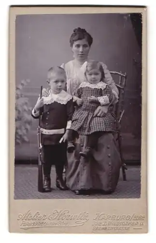 Fotografie Atelier Horwitz, Harburg / Elbe, Bremerstr., Knabe mit Gewehr nebst Mutter & Schwester