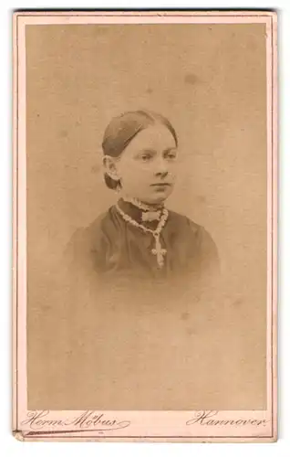 Fotografie Herm. Möbus, Hannover, Augustenstrasse 15, Portrait junge Dame mit Kragenbrosche und Kreuzkette