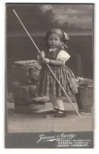 Fotografie James Aurig, Dresden-Blasewitz, Portrait kleines Mädchen im Kleid mit einem Stock