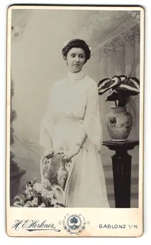 Fotografie Heinr. E. Herkner, Gablonz a. Neisse, Gebirgstrasse 22, elegante Dame mit Blumen im Haar