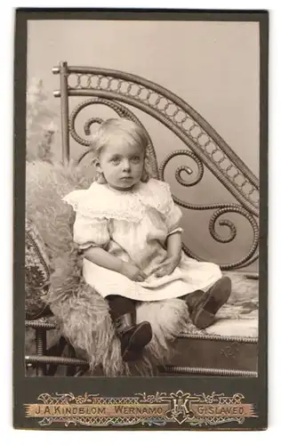 Fotografie J. A. Kindblom, Wernamo, kleines blondes Mädchen sitzt auf Fell