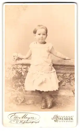 Fotografie Otto Mayer, Dresden, Prager Strasse 31, kleines Mädchen im weissen Kleid mit Blume in der Hand