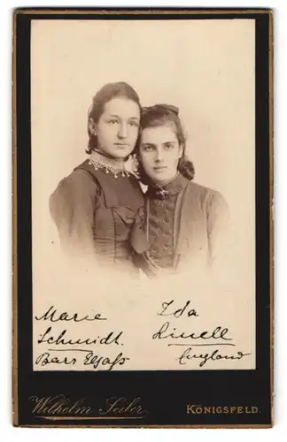 Fotografie Wilhelm Seiler, Königsfeld, Zwei junge Damen in dunklen Kleidern lehnen aneinander