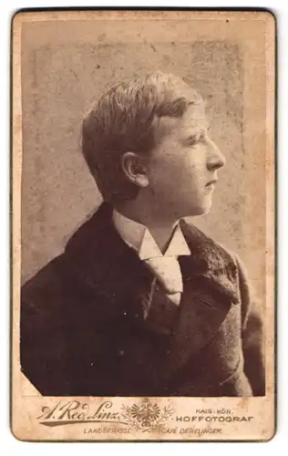 Fotografie A. Red, Linz, Junger Mann mit Pelzbesetzter Jacke im Profil