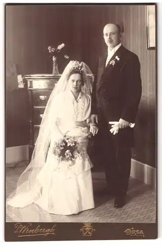 Fotografie P. Wenbergh, Orsa, Hochzeitspaar, hübsche Braut mitBrautstrauss auf Stuhl sitzend