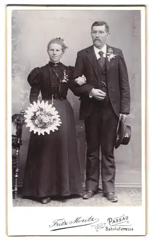 Fotografie Fritz Moritz, Passau, Bahnhofstrasse, Portrait Eheleute in Hochzeitskleidern mit Blumenstrauss und Hut