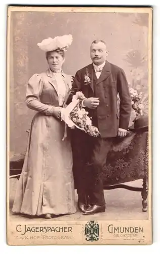 Fotografie C. Jagerspacher, Gmunden ob Oest., Portrait Hochszeitspaar mit Blumenstrauss, Braut mit elegantem Hut