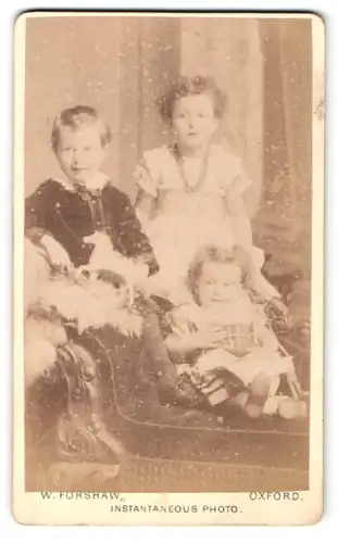 Fotografie W. Forshaw, Oxford, Portrait drei kleine Kinder in hübscher Kleidung mit Spielzeugpferd