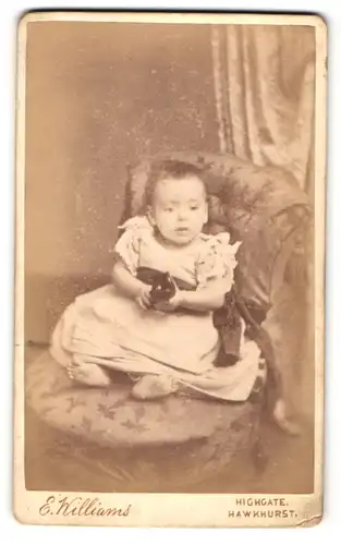 Fotografie E. Williams, Hawkhurst, Portrait süsses Mädchen mit Spielzeug