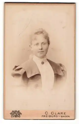 Fotografie C. Clare, Freiburg, Frau mit hellen Haaren in weisser Bluse und Jacke mit weiten Schultern