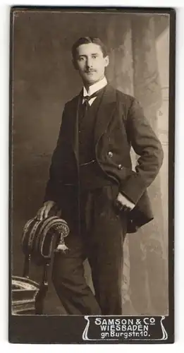 Fotografie Samson & Co., Wiesbaden, Portrait eines stehenden schönen Mannes im edlen Wollanzug mit gestreifter Krawatte