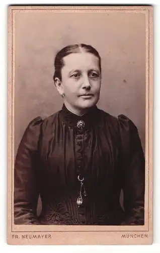 Fotografie Fr. Neumayer, München, Portrait dunkelhaarige hübsche Dame mit Brosche am Kragen