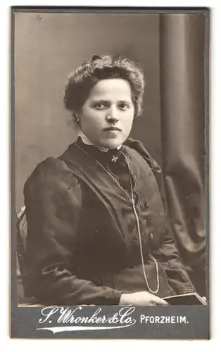 Fotografie S. Wronker & Co., Pforzheim, Portrait modisch gekleidete Dame mit einem Buch