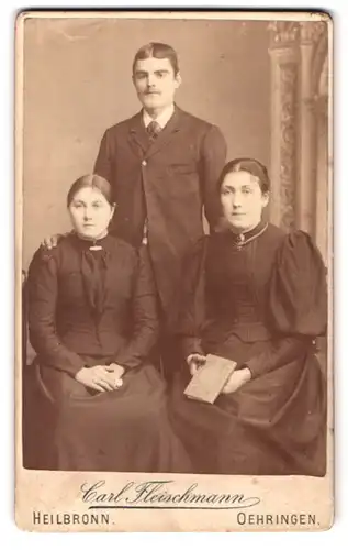 Fotografie Carl Fleischmann, Heilbronn, Portrait Mann mit zwei Frauen in vertrauter Pose
