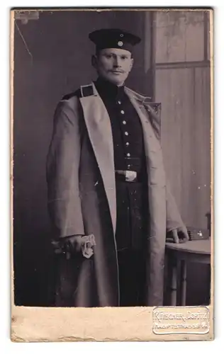 Fotografie R. Fischer, Copitz, Hauptstrasse 14, Portrait Soldat im Uniformmantel