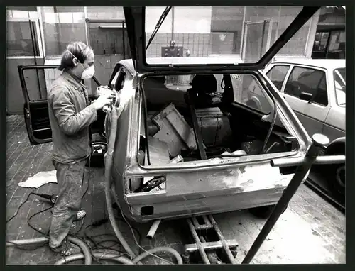 Fotografie Kfz-Werkstatt, Mechaniker schleift gespachtelte Schadstelle am VW Golf I, Volkswagen Auto