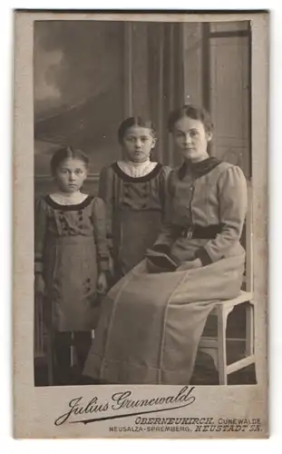 Fotografie Julius Grunewald, Oberneukirch, Portrait stolze Mutter mit zwei Töchtern in eleganten Kleidern