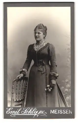 Fotografie Emil Schlippe, Meissen, Elbberg 1, Portrait Frau im schönen Kleid mit Blüte in Händen