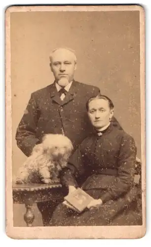 Fotografie P. E. Nickelsen, Westerland auf Sylt, Portrait älteres Paar in hübscher Kleidung mit Hund