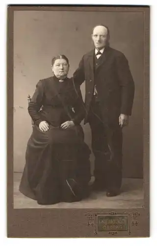 Fotografie Knut Anderson, Örebro, Ekersgatan 20, Portrait älteres Paar in zeitgenössischer Kleidung
