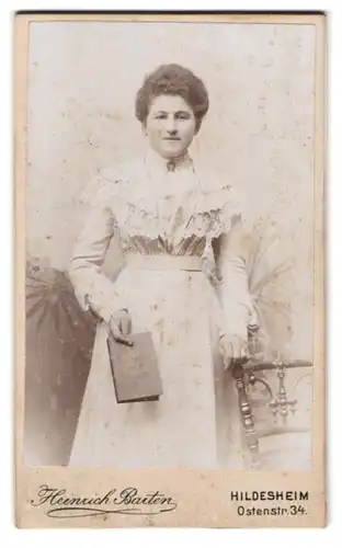 Fotografie Heinrich Barten, Hildesheim, Portrait junge Dame im Kleid mit Buch in der Hand