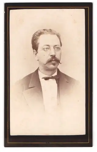 Fotografie Anton Brand, M. Ostrau, Portrait eines elegant gekleideten Mannes mit Brille und Schnurrbart