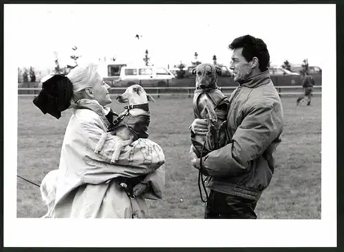 Fotografie Hunderennbahn, Hundebesitzer halten Windhund im Arm