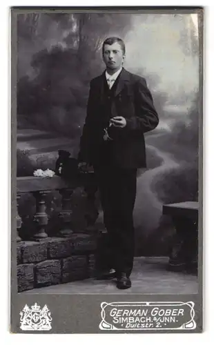 Fotografie German Gober, Simbach a /Inn, Dultstrasse 2, Portrait junger Herr im Anzug mit Zigarre