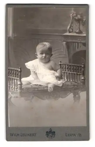 Fotografie Wilh. Leukert, Leipa i. B., Brückenstrasse, kleines Kind im weissen Hemd mit traurigen Blick