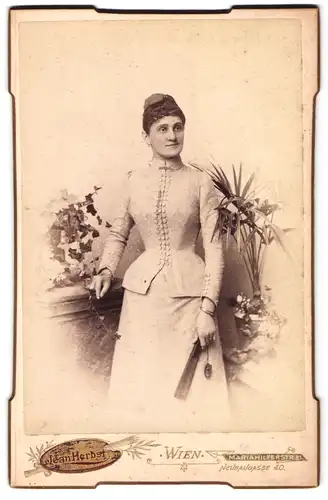 Fotografie Jean Herbst, Wien, Neubaugasse 40, Dame in eleganter Kleidung in stehender Pose, Fächer