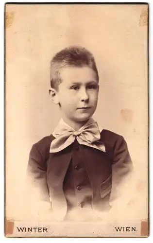 Fotografie Winter, Wien, Reisnerstrasse 11a, kleiner Junge in eleganter Kleidung mit heller Schleife