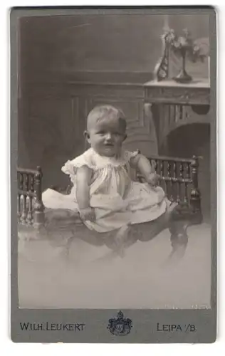 Fotografie Wilh. Leukert, Leipa i. B., Brückenstrasse, Säugling auf Hocker sitzend