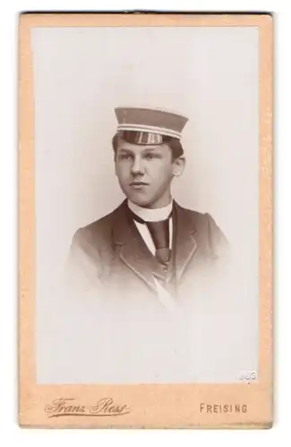 Fotografie Franz Ress, Freising, Portrait Student mit Mütze trägt Anzug und Krawatte
