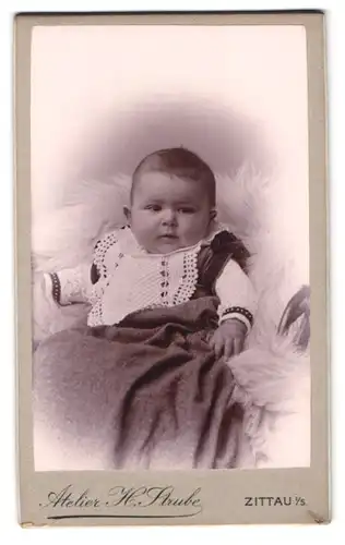 Fotografie H. Strube, Zittau i /S., Lessingstrasse 14, Portrait süsses Kleinkind im Kleid mit Latz