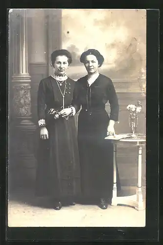 Foto-AK zwei hübsche Damen an einem Tisch stehend