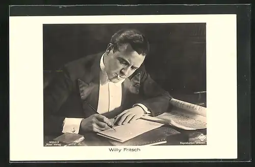 AK Schauspieler Willy Fritsch mit Notenblatt am Schreibtisch rauchend