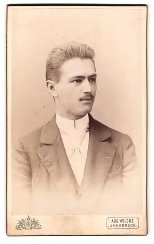 Fotografie Aug. Wilcke, Innsbruck, Rudolfstr. 1, Portrait blonder junger Mann mit Krawatte im Jackett