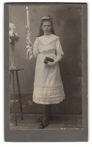 Fotografie Fotograf und Ort unbekannt, Portrait Mädchen im weissen Kleid mit Kerze und Bibel zur Kommunion