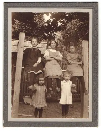 Fotografie unbekannter Fotograf und Ort, Mädchen auf Gerüst zum Teppichklopfen sitzend