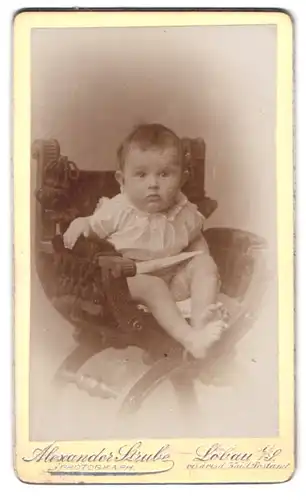 Fotografie Alexander Strube, Löbau i. S., Poststr., 309, Portrait Kleinkind im weissen Kleid sitzt im Stuhl
