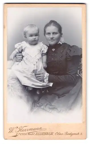 Fotografie W. Herrmann, Eisenach, Obere Predigerstr. 4, Portrait Mutter im schwarzen Kleid mit Kleinkind auf dem Schoss