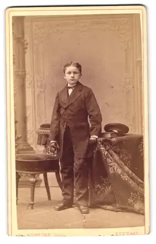 Fotografie H. Strube Junr., Zittau, Lessing-Str. 14, Portrait junger Knabe im Anzug mit Schirmmütze und Lederhandschuhen