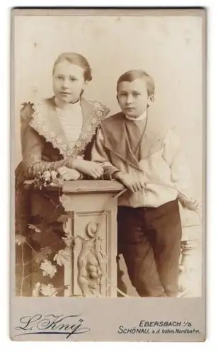 Fotografie L. Kny, Ebersbach i. S., Portrait Bruder und Schwester im Matrosenanzug und Kleid mit Spitze